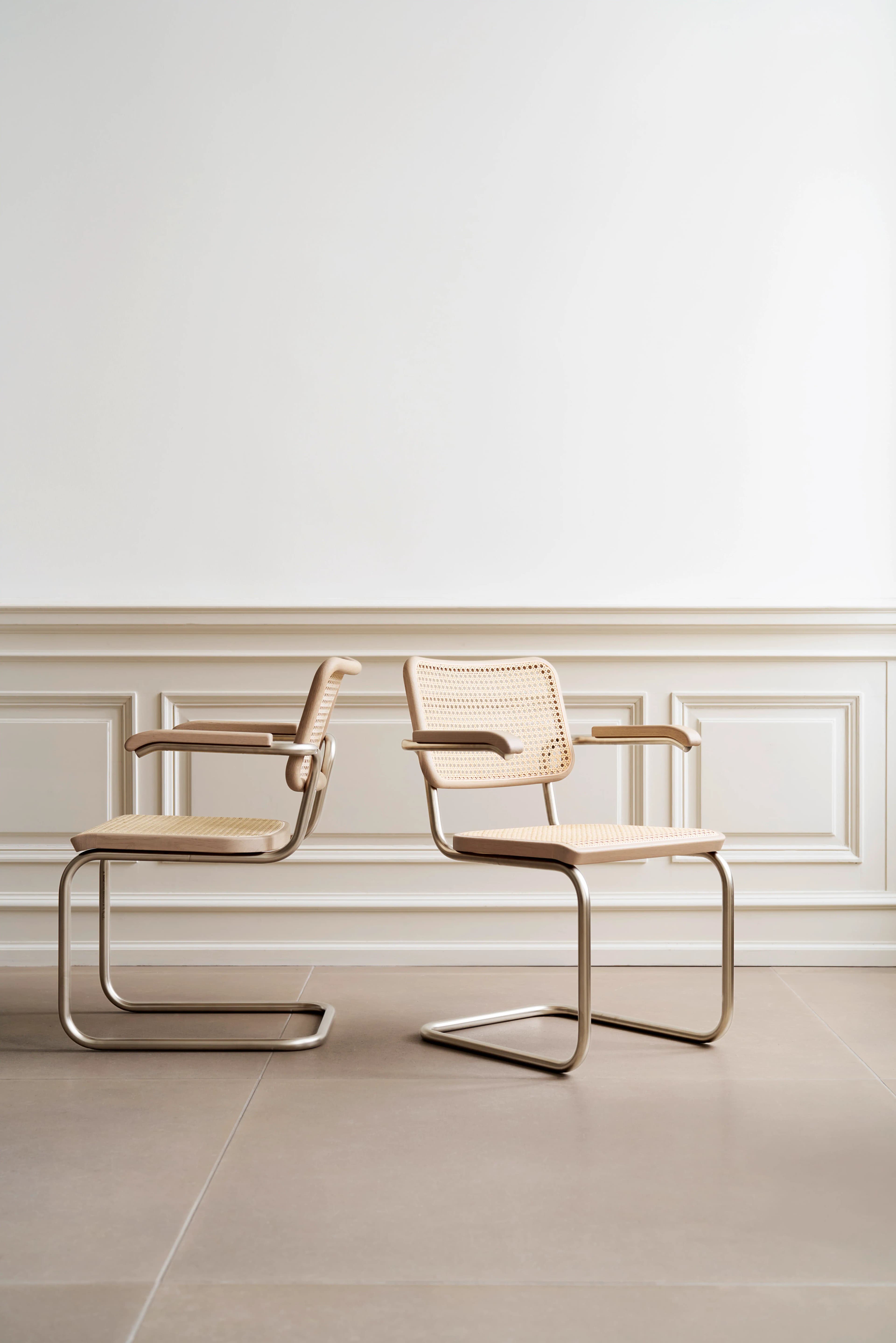 Editorial image for JS . THONET: Two Thonet S 64 NORDIC cantilever chairs with cane seat and backrest in a minimalist room.