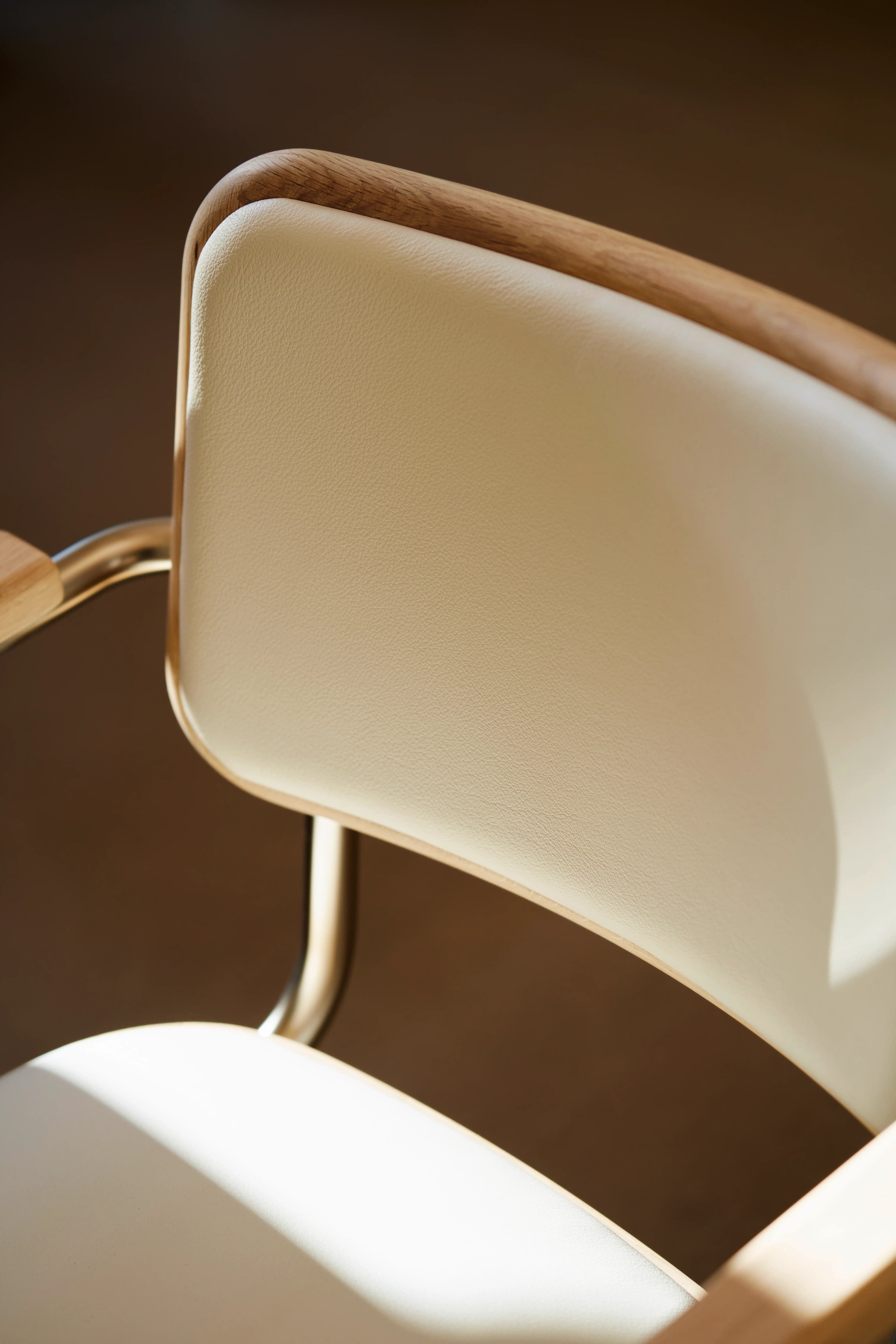 Editorial image for JS . THONET: Detail shot of a Thonet S 64 NORDIC chair with light leather upholstery and a wooden frame.