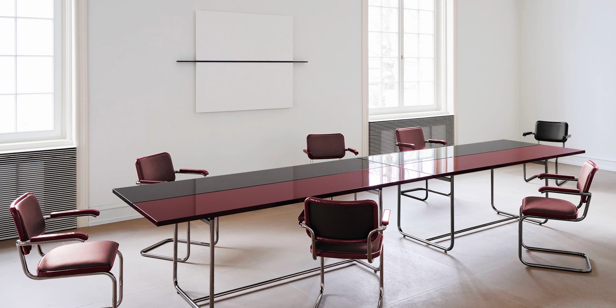 Editorial image for JS . THONET: S 64 SERIOUS cantilever chair with leather upholstery beside a dining table in a minimalist room.