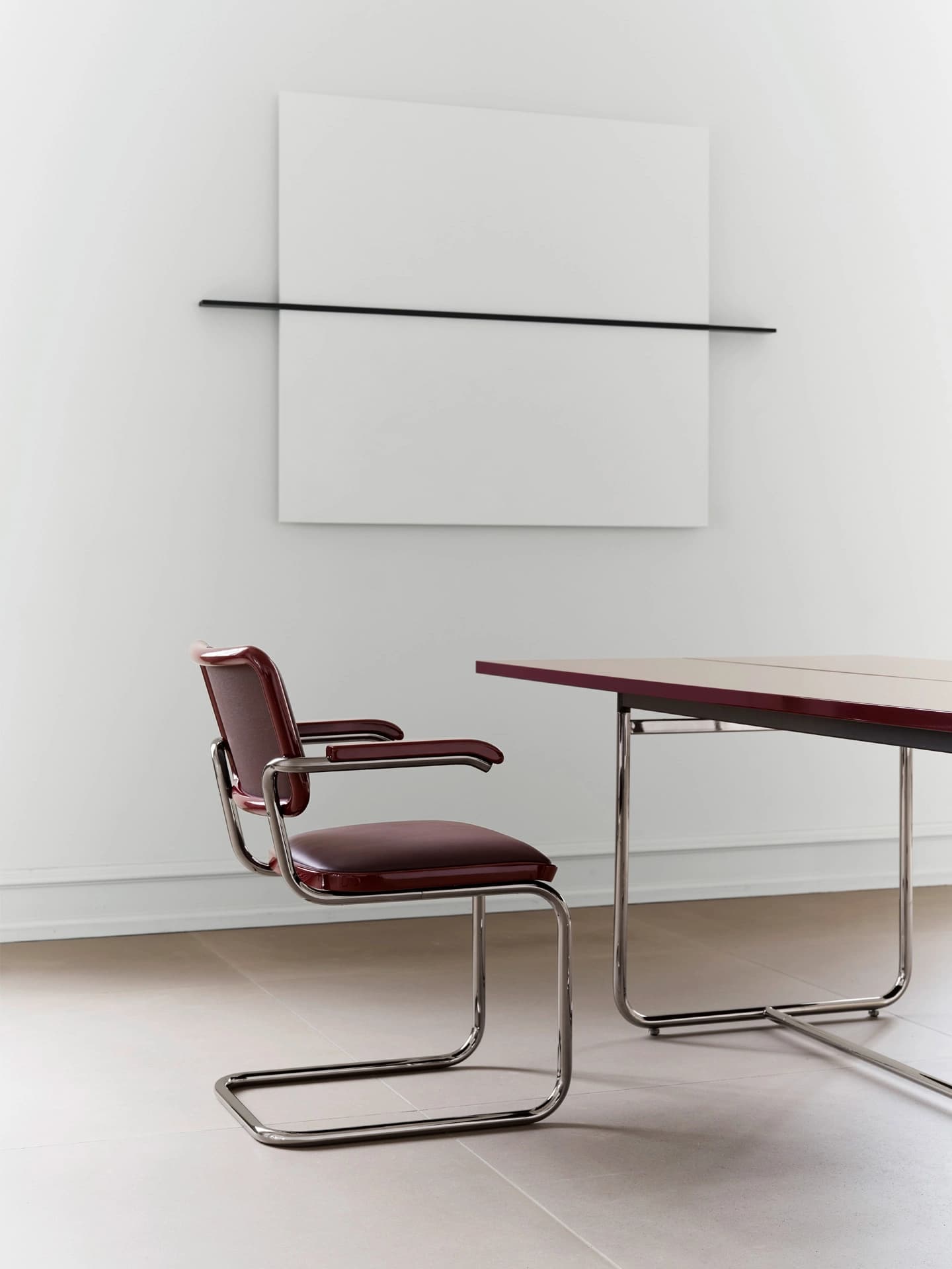 Editorial image for JS . THONET: S 64 SERIOUS cantilever chair with leather upholstery beside a dining table in a minimalist room.