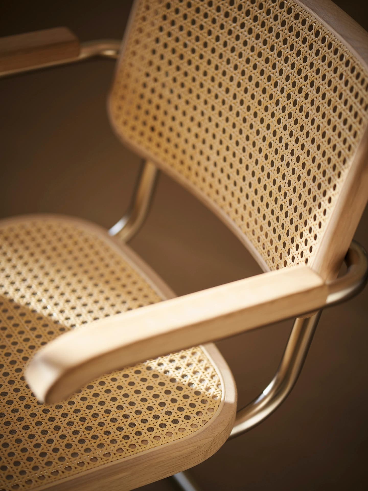 Detail shot for JS . THONET: S 64 Nordic Edition chair with cane seat and backrest and wooden armrests.