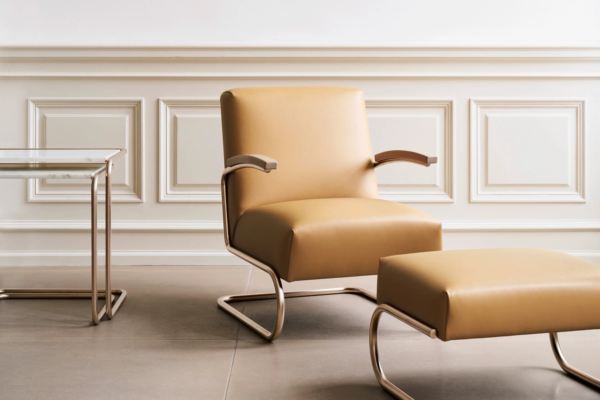 Editorial image for JS . THONET: S 411 lounge chair with leather upholstery and matching S 411 H ottoman next to a side table Set B97.
