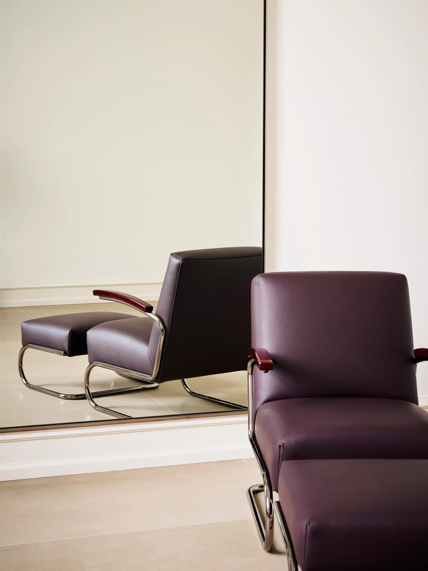 Editorial image for JS . THONET: S 411 DINING cantilever armchair with leather upholstery, shown in front of a mirror.