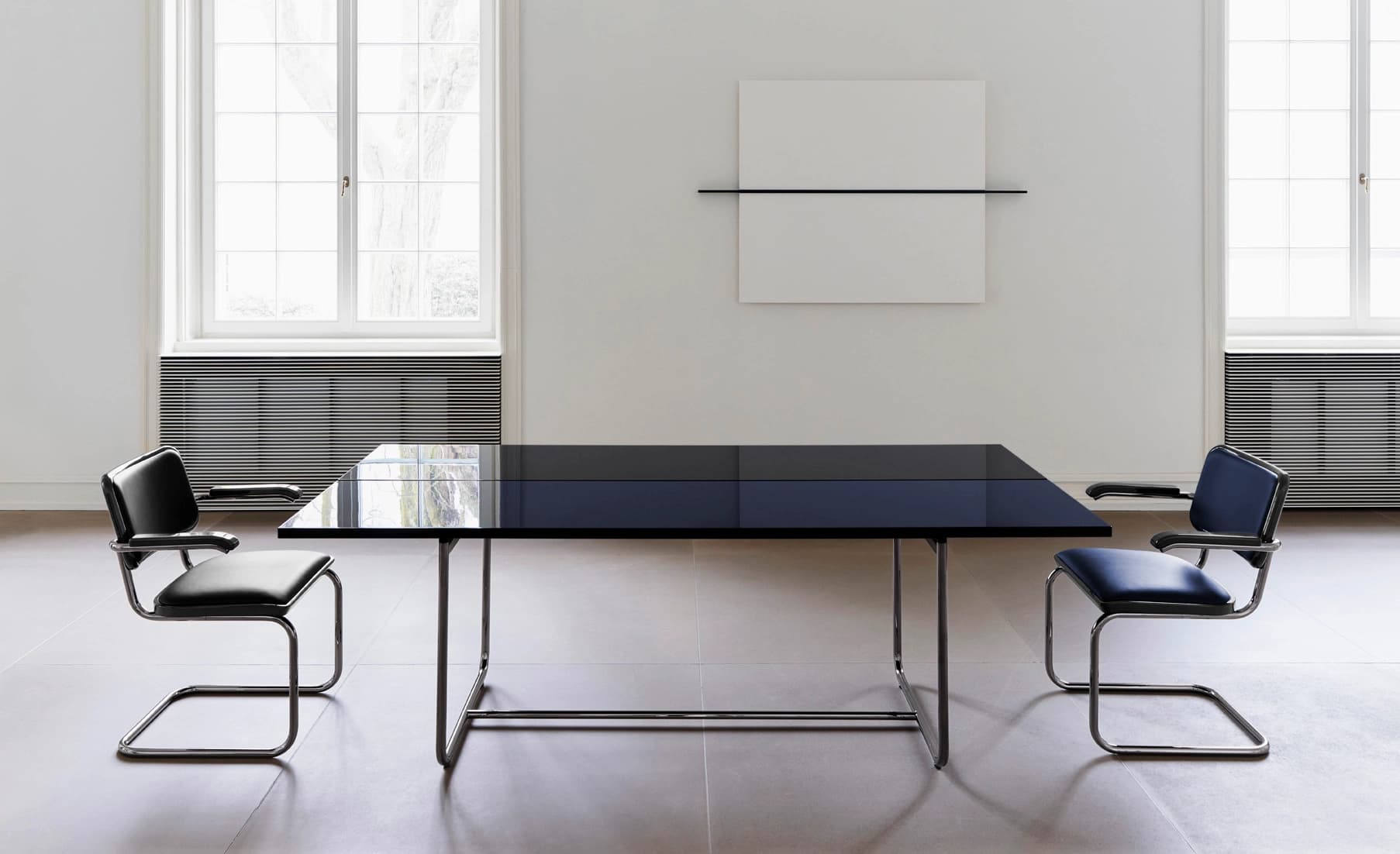 Editorial image for JS . THONET: S 64 SERIOUS cantilever chairs with leather upholstery around a table in a minimalist room.