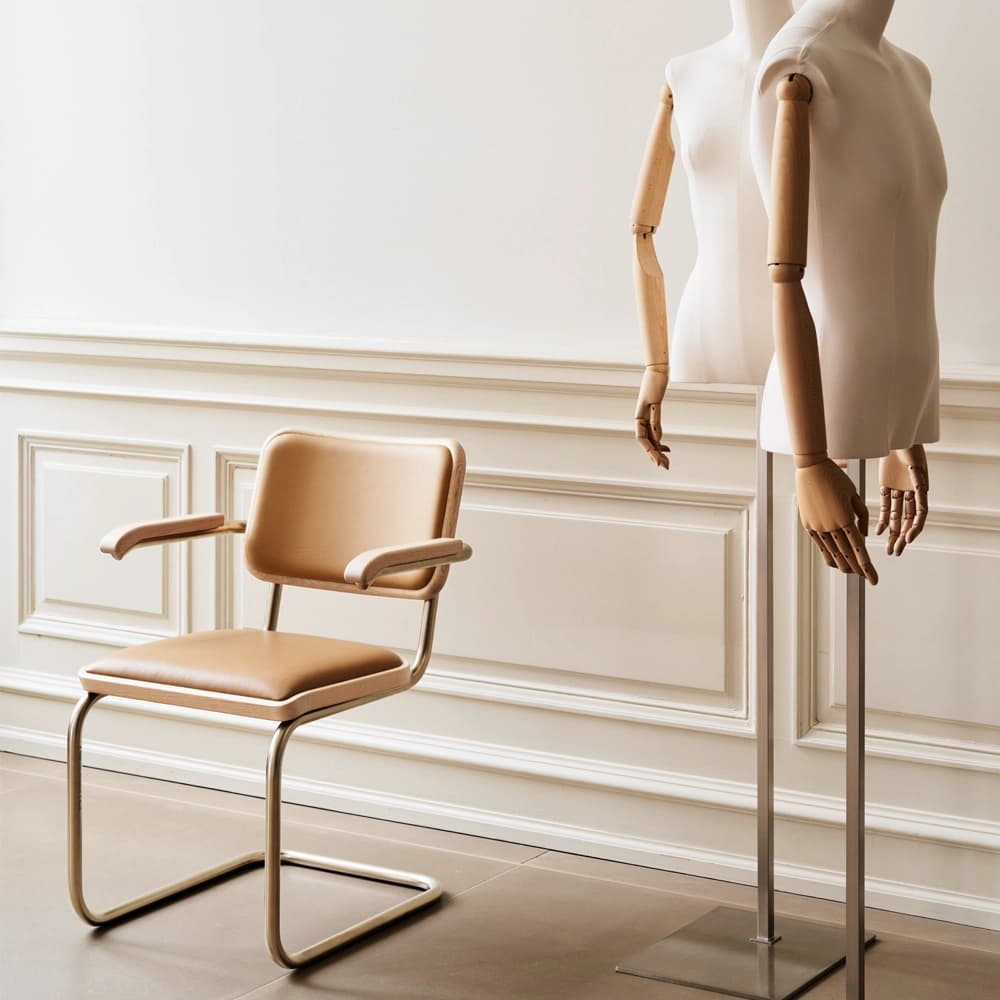 Editorial image for JS . THONET: S 64 NORDIC cantilever chair with leather-upholstered seat and backrest, shown beside a dress form in a minimalist room.