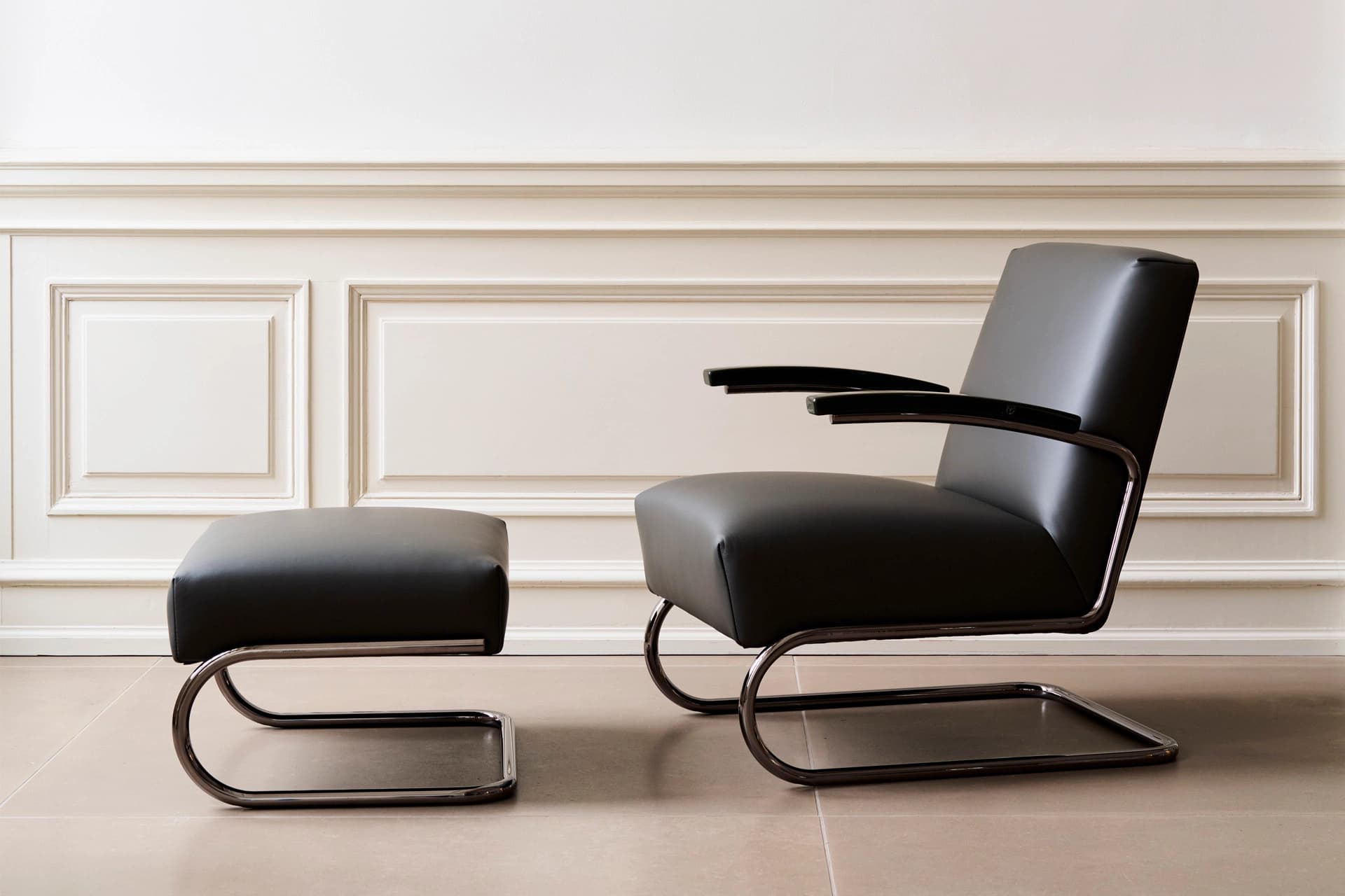 Editorial image for JS . THONET: S 411 DINING cantilever lounge chair with leather upholstery and matching ottoman in a minimalist room.